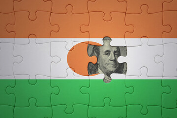 puzzle with the national flag of niger and usa dollar banknote. finance concept