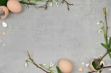 Easter decoration with feathers, branches, flowers, leaves, eggs, egg shells on grey background ...