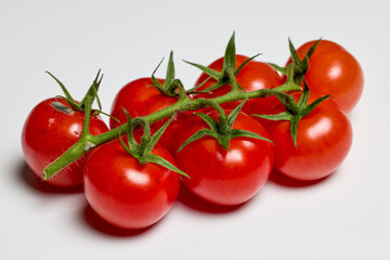 bunches of organic tomatoes on a white counter.