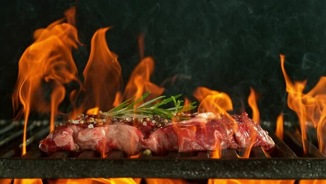 Super Slow Motion of Beef Steak on Grill With Fire, Isolated on Black Background. Filmed on High Speed Cinema Camera, 1000 fps.