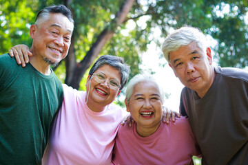 Group of elderly Asians exercising in outdoor park Meet and talk in a fun way. Health care in...