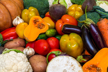 Various vegetables are laid out on a wooden table. Large assortment of vegetables food. pumpkin cabbage broccoli pepper tomatoes carrots and others