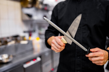 Chef sharpening a kitchen knife with Honing steel