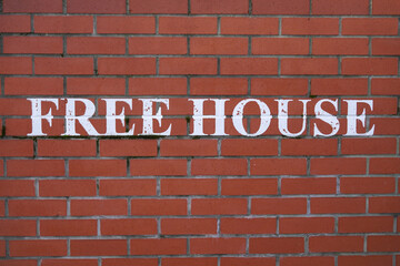 Fototapeta na wymiar Free House sign painted on wall of English pub. Place to have a beer 
