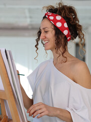 Happy smiling woman artist working in painting atelier. Inspiration, Happiness, Creativity concept.