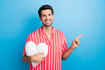 Portrait of pleasant guy with stubble wear stylish shirt hold fluffy heart directing at sale empty...