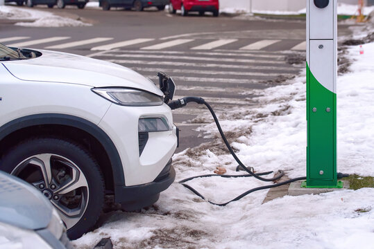 Minsk, Belarus. Jan 28, 2024. Electric car Honda M-NV Dongfeng, charge battery at paking lot in cold winter season. EV SUV charging at charge point at city street. Electric vehicle - EV car.