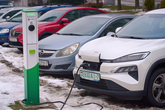 Minsk, Belarus. Jan 28, 2024. Electric car Honda M-NV Dongfeng, charge battery at paking lot in cold winter season, diesel and petrol cars parked in a row on background