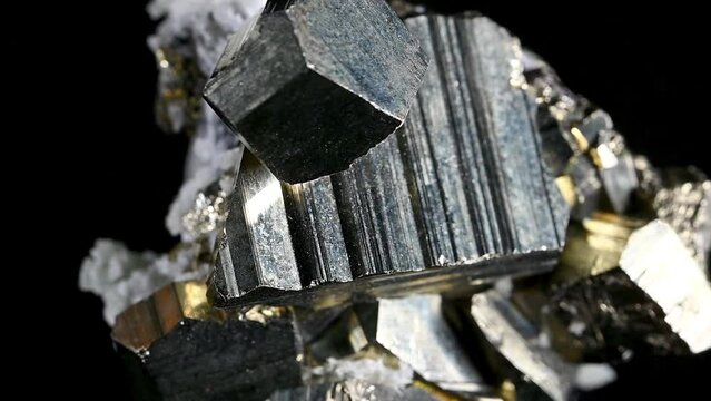 Iron Pyrite (fool's gold) cubic crystals and quartz rotating against a black background
