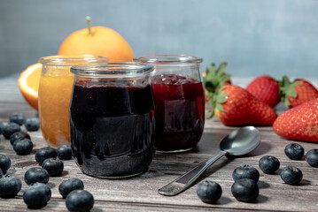 Homemade blueberries marmalade, assortment of homemade jams in glass jars. Front view, seasonal...