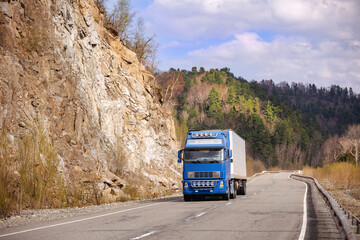 Blue truck on a mountain road in early spring
