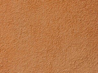 Textured plaster on a wall in the color orange, texture