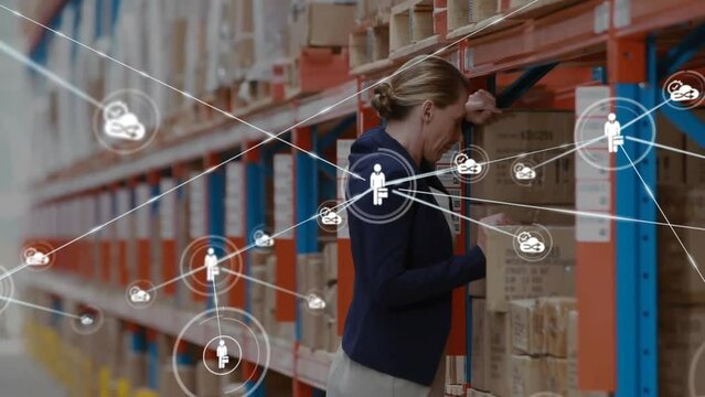 Animation of network of business and cloud icons over sad female manager at warehouse