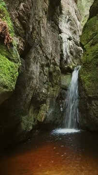 Waterfall in the rocks in the national park of Adrspach-Teplice Rocks, Czech Republic. Vertical video