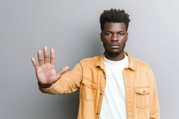 Fototapeta premium Black man extending his hand making a stop sign.