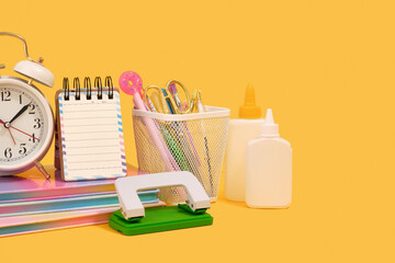 School and office supplies in the workplace. Vintage alarm clock and stapler. Copy space for text.