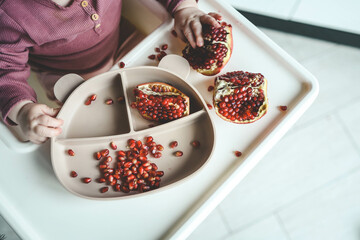 Baby eats pomegranate, first complementary feeding concept
