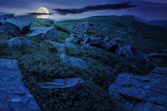 white stones and boulders on the hillside of carpathian mountain range at night. wonderful nature scenery in full moon light
