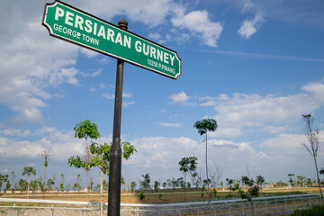 Gurney Drive street sign in George Town, Penang, Malaysia with newly constructed marina bay as background.