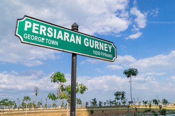 Gurney Drive street sign in George Town, Penang, Malaysia with newly constructed marina bay as background.