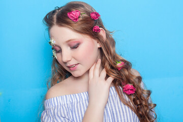 Positive girl. Little girl with daisies in her hands on a blue background.