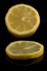 Slice of yellow lemon and lemon with dark black background in vertical Citrus aurantifolia