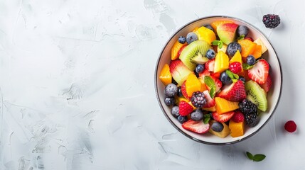Bowl of fresh exotic fruit salad on white summer background Healthy breakfast Copy space Top view