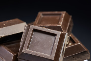 Dark chocolate stack, chips and powder close up