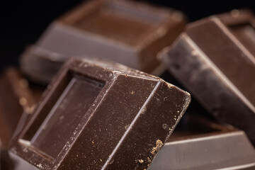 Dark chocolate stack, chips and powder close up