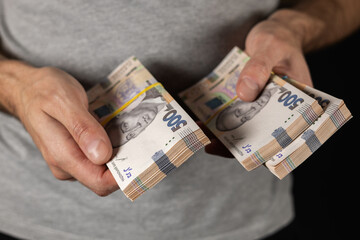 Man holds bundles of hryvnia in her hand. Ukrainian money. Business concept. 500 hryvnia banknotes