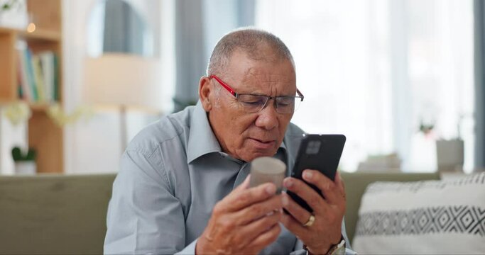 Phone, pills and senior man at home, reading label, medicine information and confused for telehealth service or FAQ. Elderly person on sofa with pharmaceutical bottle or tablet with mobile questions
