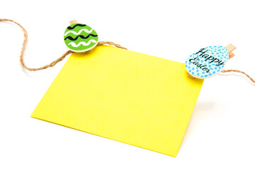 Greeting blank card hanging on a rope on clothespins with colored eggs. Copy space. Free space for text. Happy easter!	