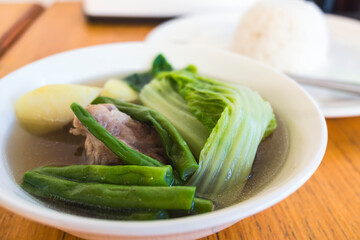 Nilagang Baka or Filipino boiled beef soup with vegetables served with rice at a Filipino restaurant.