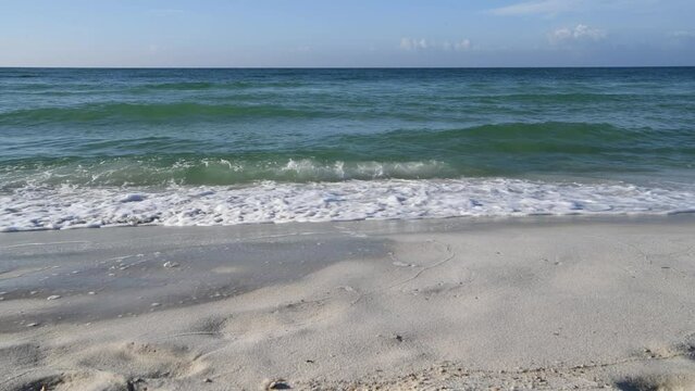 Emerald and Turquoise waves rolling up on a white sand beach in Florida