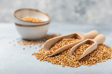 Green buckwheat in a wooden spoon on a wooden kitchen table.Superfood.Raw buckwheat porridge.Healthy vegan food concept, eco products, diet. Copy space.Organic food.weight loss and proper nutrition.