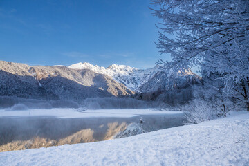 Fototapeta na wymiar 冬の上高地スノーハイク大正池に映る穂高連峰