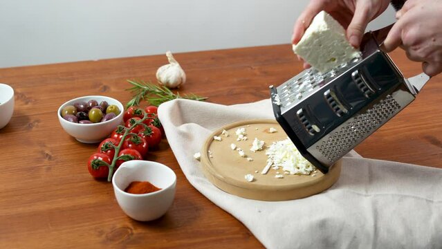 Shredded cheese on hexagonal graters on wooden table