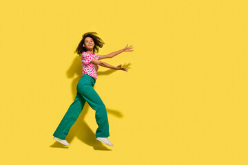 Fototapeta na wymiar Full length profile photo of cheerful overjoyed person jump rush arms catch empty space isolated on yellow color background