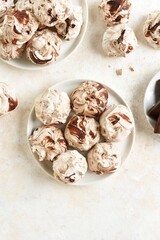 Homemade chocolate meringue cookies on plate over light background