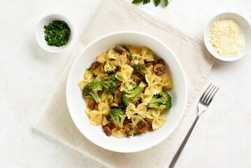 Farfalle pasta with roasted broccoli and mushrooms. Top view, flat lay