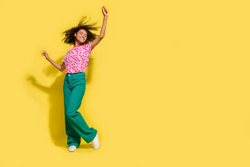 Full body photo of excited cheerful lady rejoice clubbing dancing empty space isolated on yellow color background
