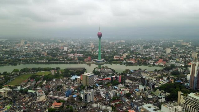 Aerial footage over Colombo skyline featuring the Lotus Tower amid modern and historic architecture, reflective lakes, and busy urban life, suggesting tourism, real estate, urban development concepts.