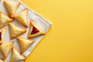 Fotobehang hamantaschen cookies with jam lie on a white linen napkin on the yellow color background, minimalism, copy space. Concept: traditional dishes and Purim holiday. © Anastasiia