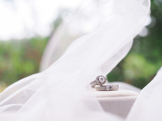 Diamond engagement wedding rings on bridal veil. Wedding accessories. Valentine's day and Wedding day concept.