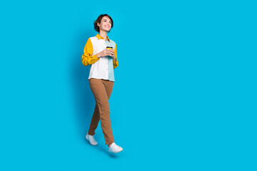 Photo of positive girl worker hold cappuccino cup walking isolated blue color background