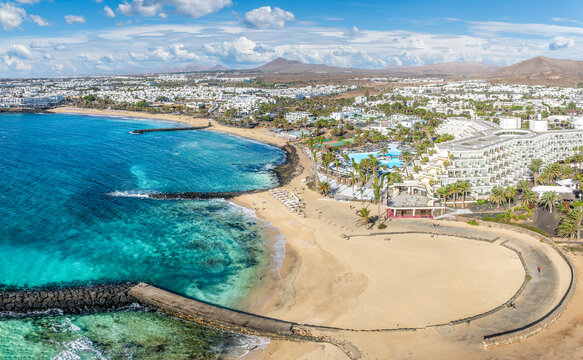 Playa de las Cucharas, Costa Teguise, Lanzarote: A perfect family beach with golden sand, turquoise waters, and a variety of water sports.