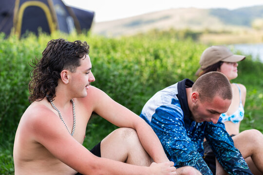 Group of Aussie teens sitting together together on a summer afternoon by a lake