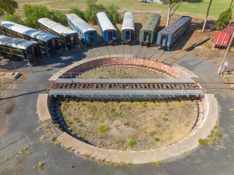 Aerial view of long train carriages lined up around a railway turntable