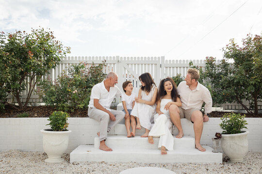 Family of five sitting on backyard steps