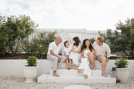 Family of five sitting on backyard steps